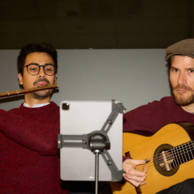 Die Band Roda de Choro de Dresden . Ein Mann mit Gitarre rechts und einer mit Querflöte links.
